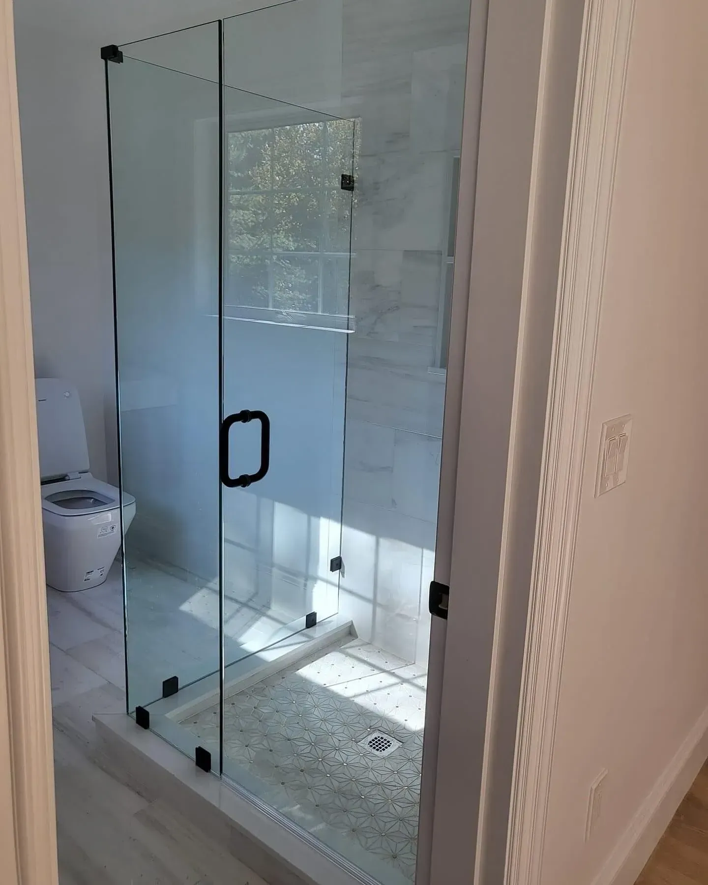 Finished glass shower enclosure with dark hardware