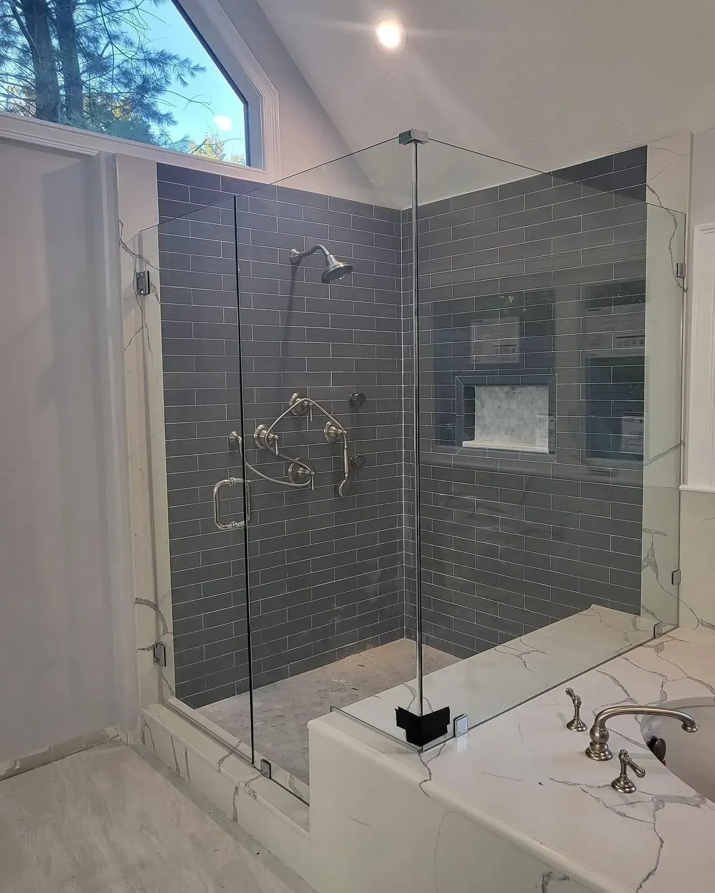 Custom glass shower enclosure with dark hinges and handle