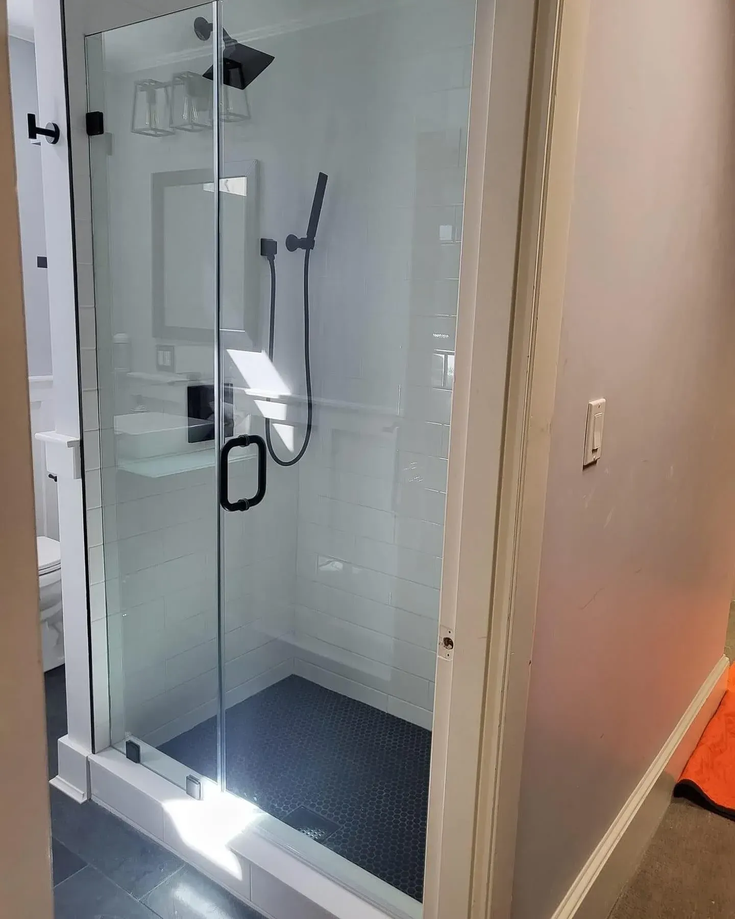 Frameless shower glass fitted around a bathroom opening