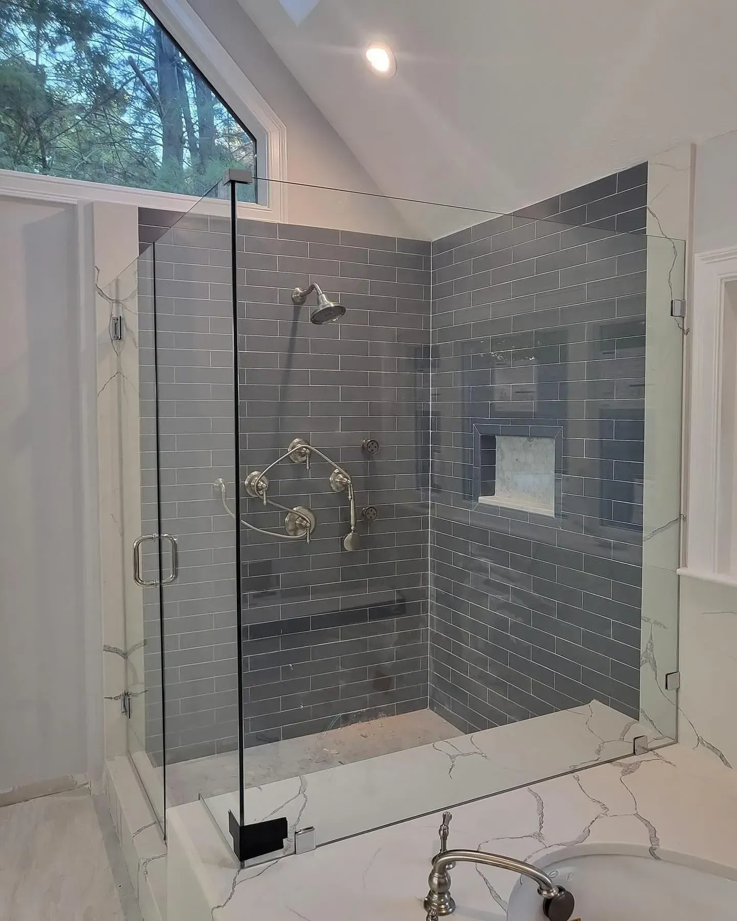 Semi-frameless shower enclosure with dark metal accents