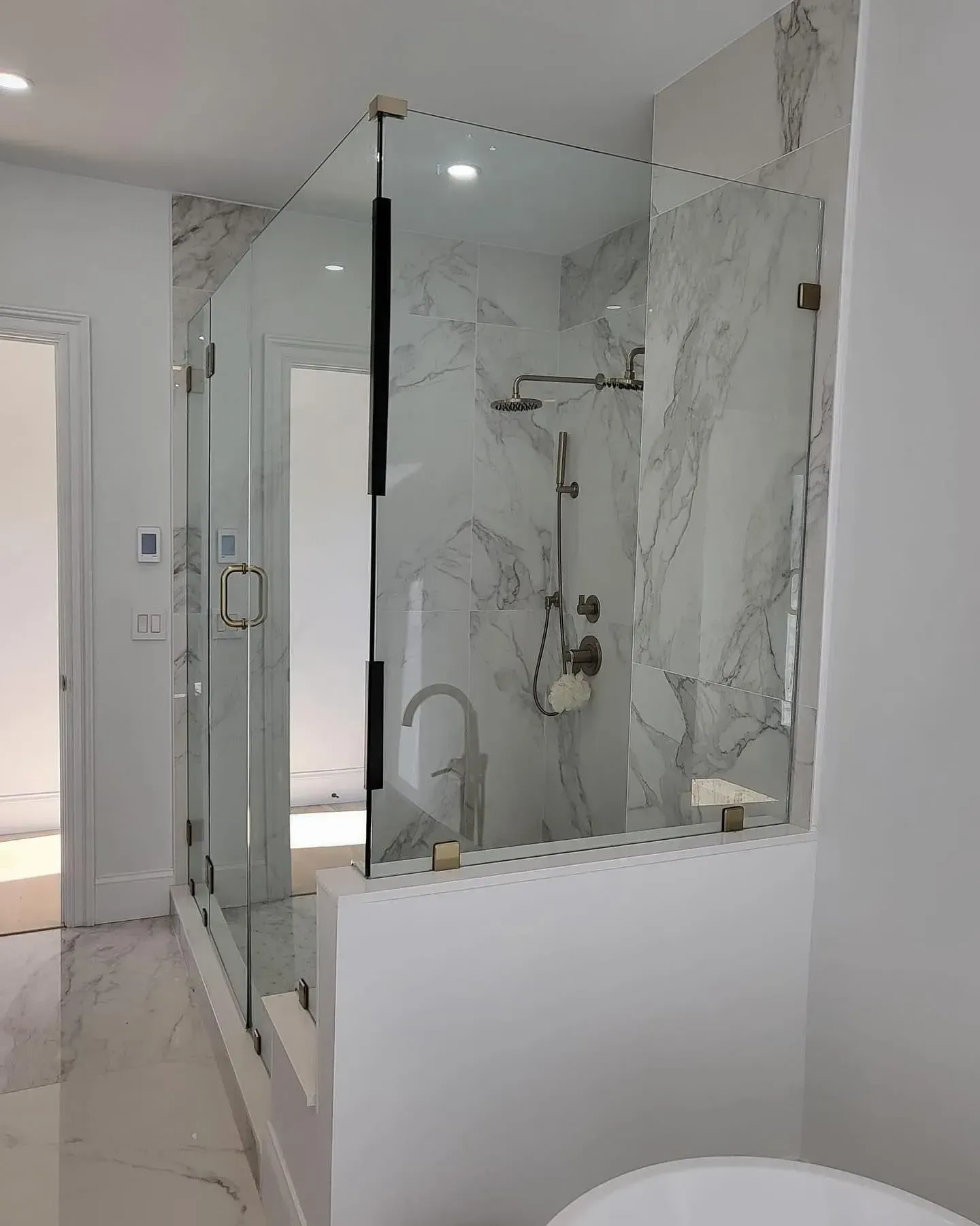 Semi-frameless glass shower door with visible support hardware