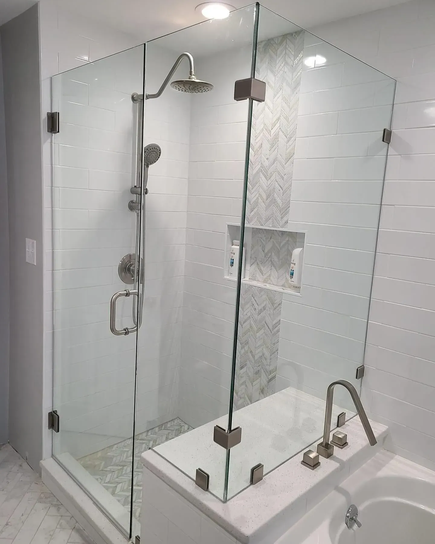 Close view of shower door glass, hinge, and seal area