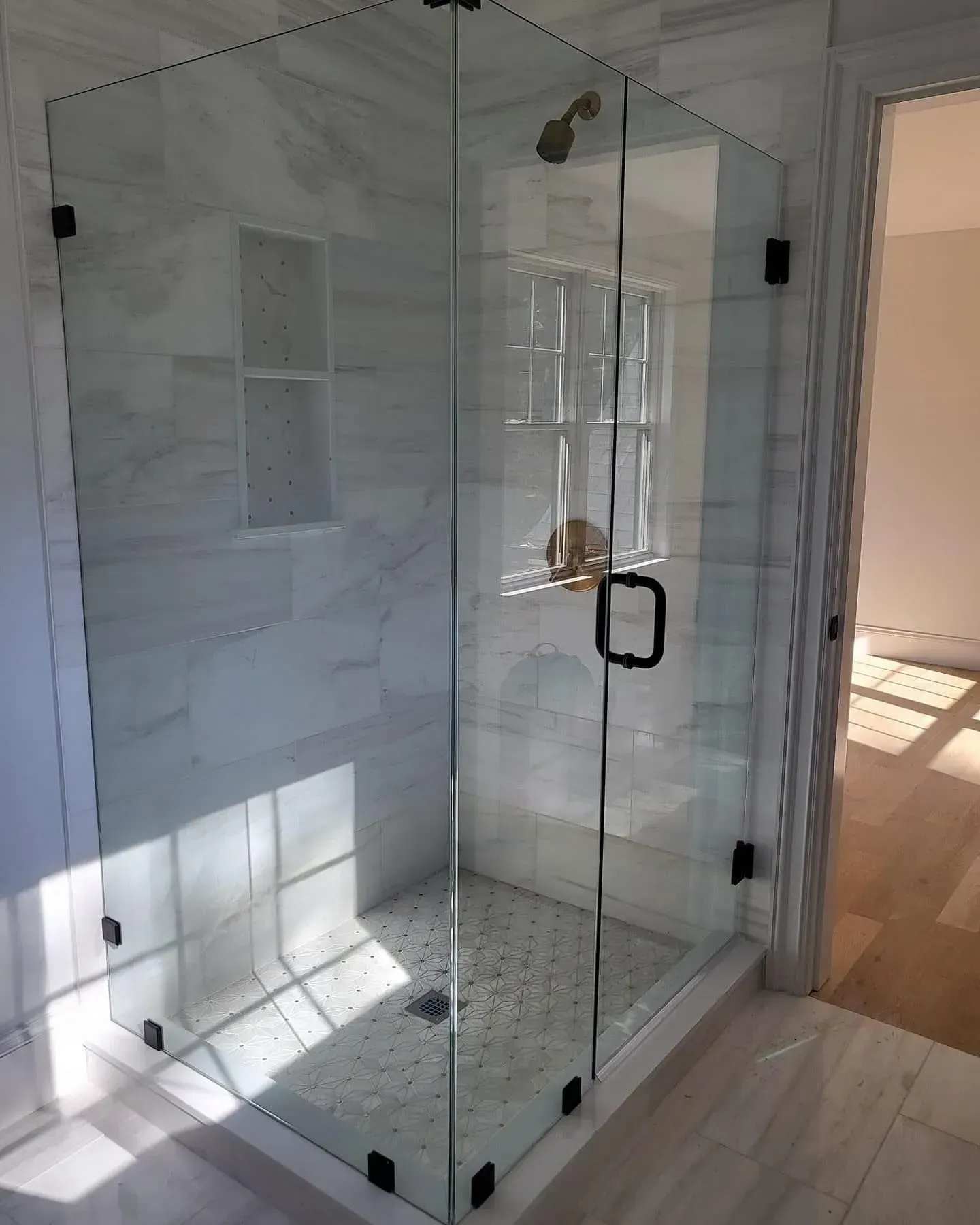 Glass shower enclosure showing visible framing and clear panels