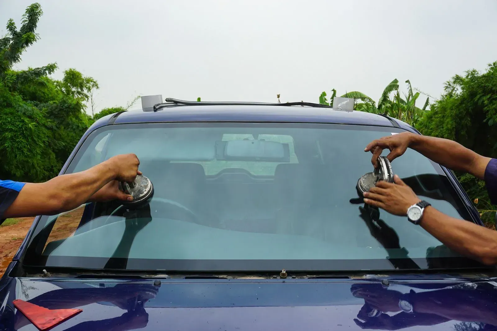 Technicians setting replacement windshield glass