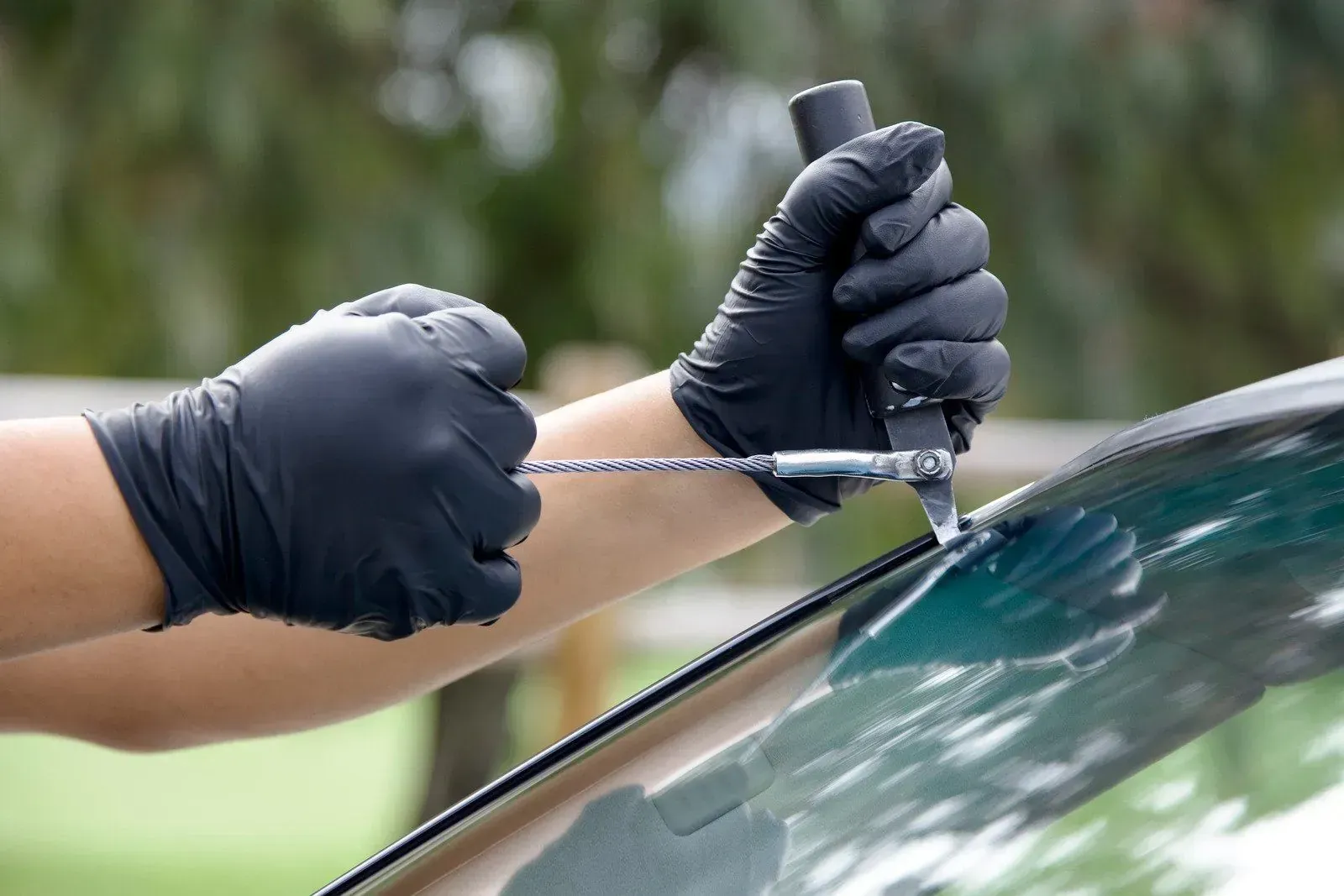 Windshield removal tool in use during auto glass service