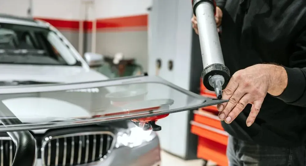 Technician preparing a vehicle for windshield installation