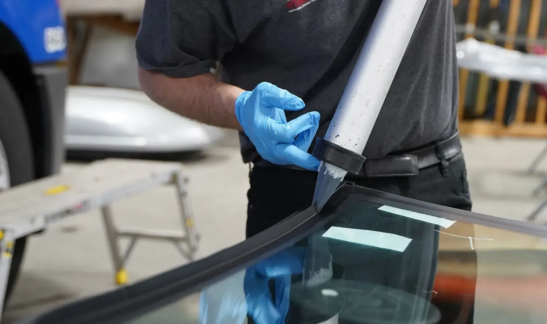 Close view of sealant application during auto glass work
