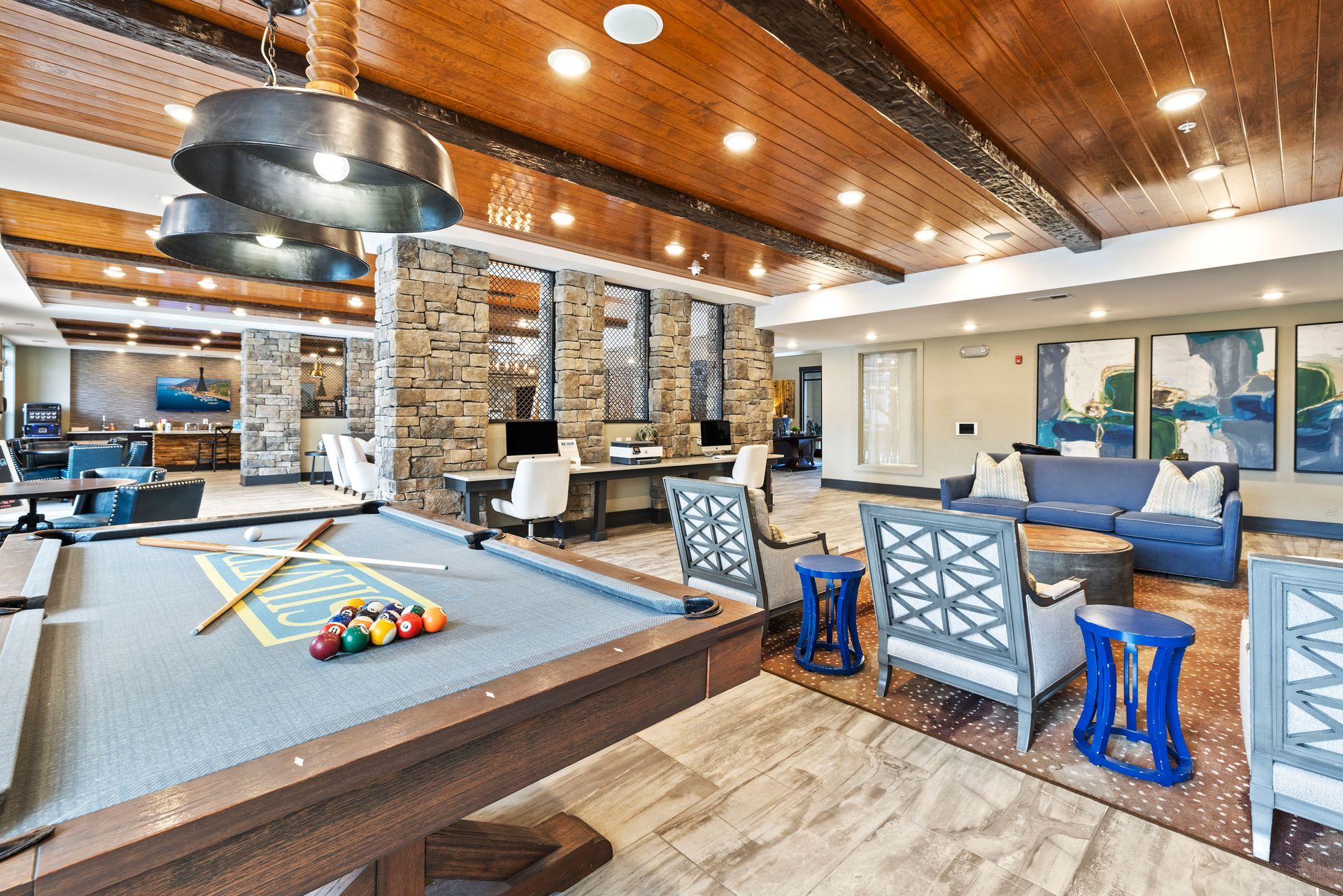 Silver Collection at The Park resident game room with a pool table, bar seating, stone fireplace, and wood ceiling in Huntersville, NC.