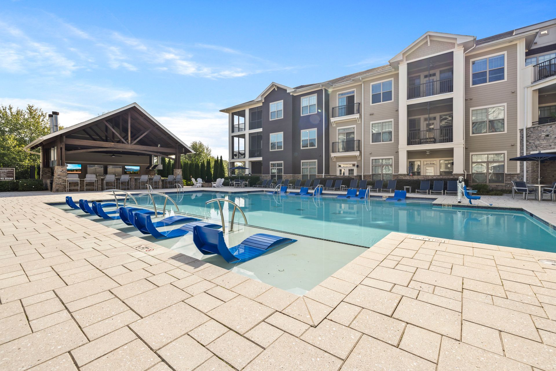 Silver Collection at The Park outdoor apartment pool with blue lounge chairs, shaded pavilion, and resort-style amenities in Huntersville, NC.