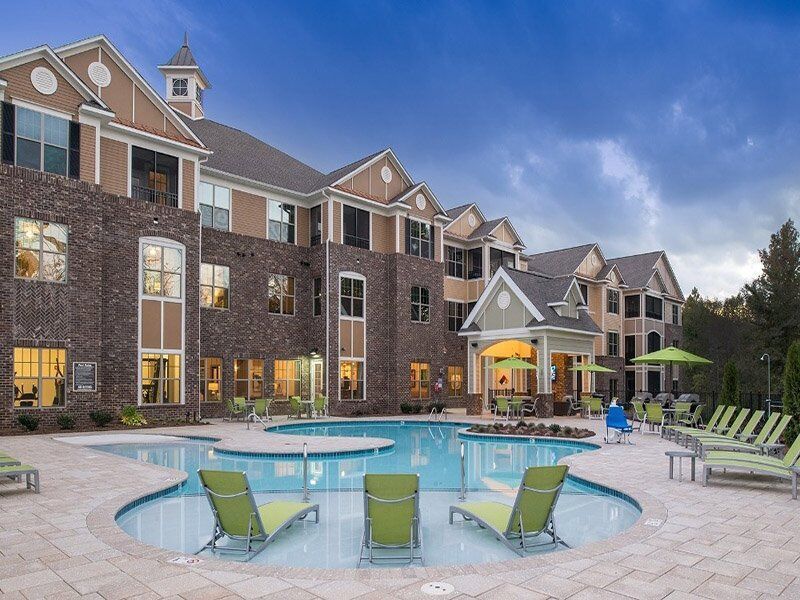 A large building with a large swimming pool in front of it