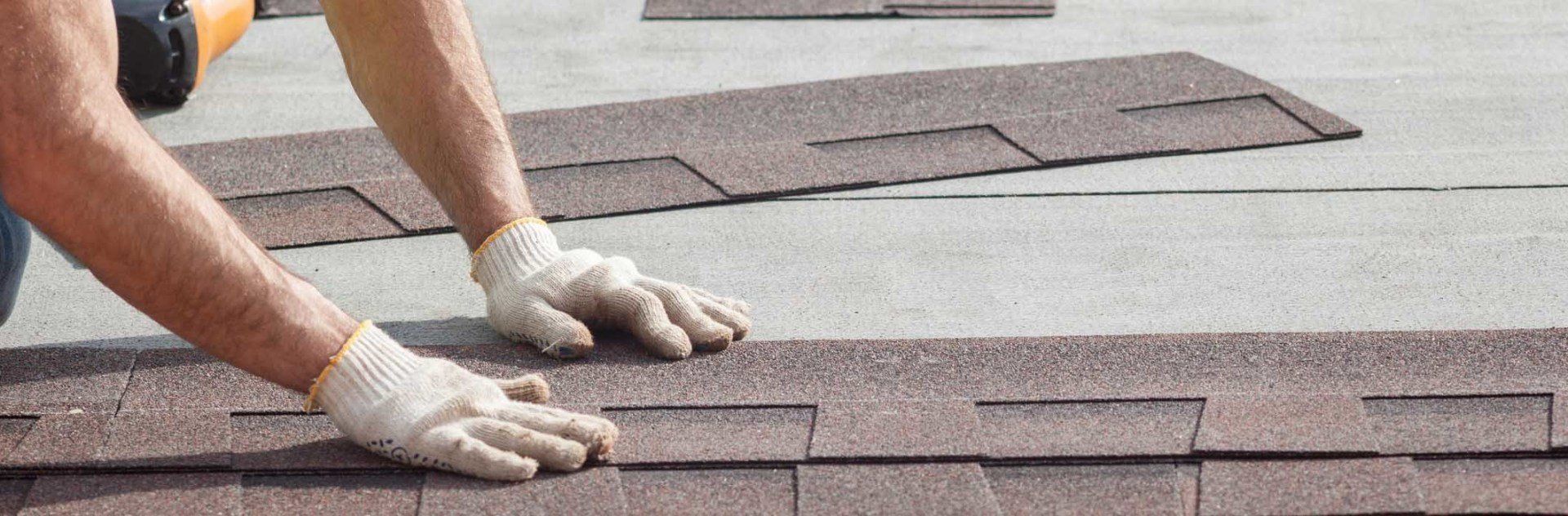 Workers on roof with electric drill — Roofing Professionals Panama City, FL Workers on roof with electric drill — Roofing Professionals Panama City, FL