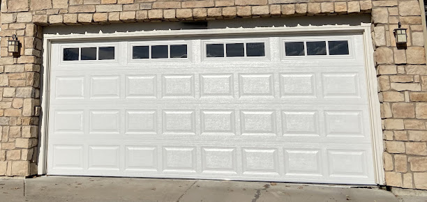 White double garage door set into a stone exterior wall