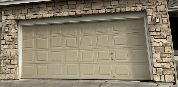Beige garage door set in a stone exterior wall