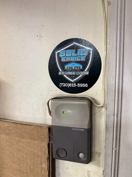 Wall-mounted security keypad under a round “Solid Guard” sticker, with a small green indicator light.