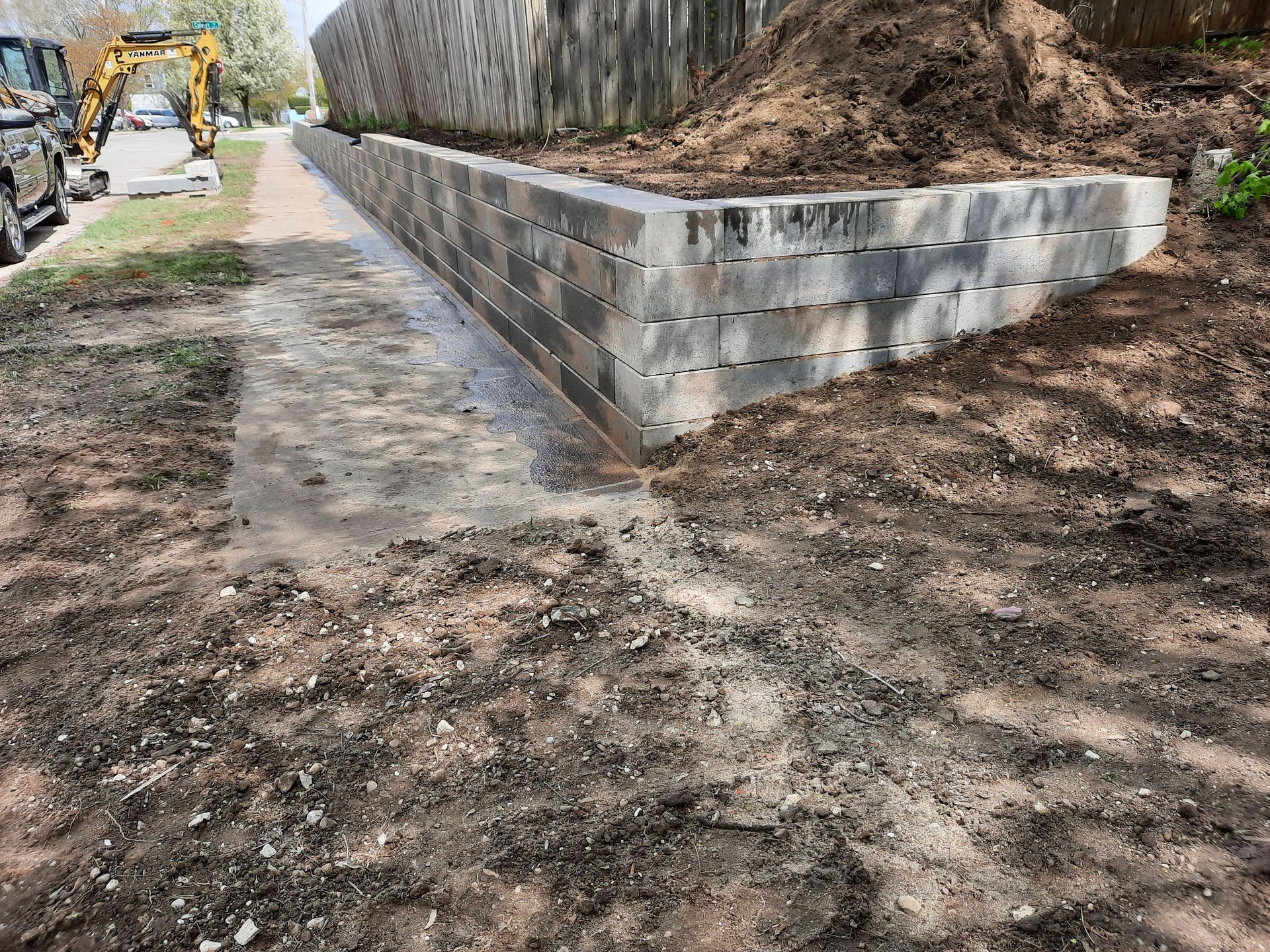 A concrete wall is being built next to a dirt path.