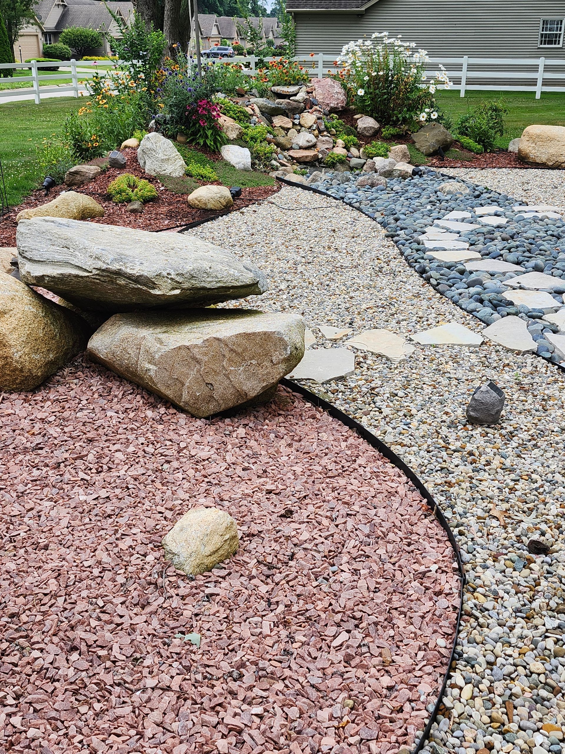 A garden filled with rocks and gravel with a path going through it.