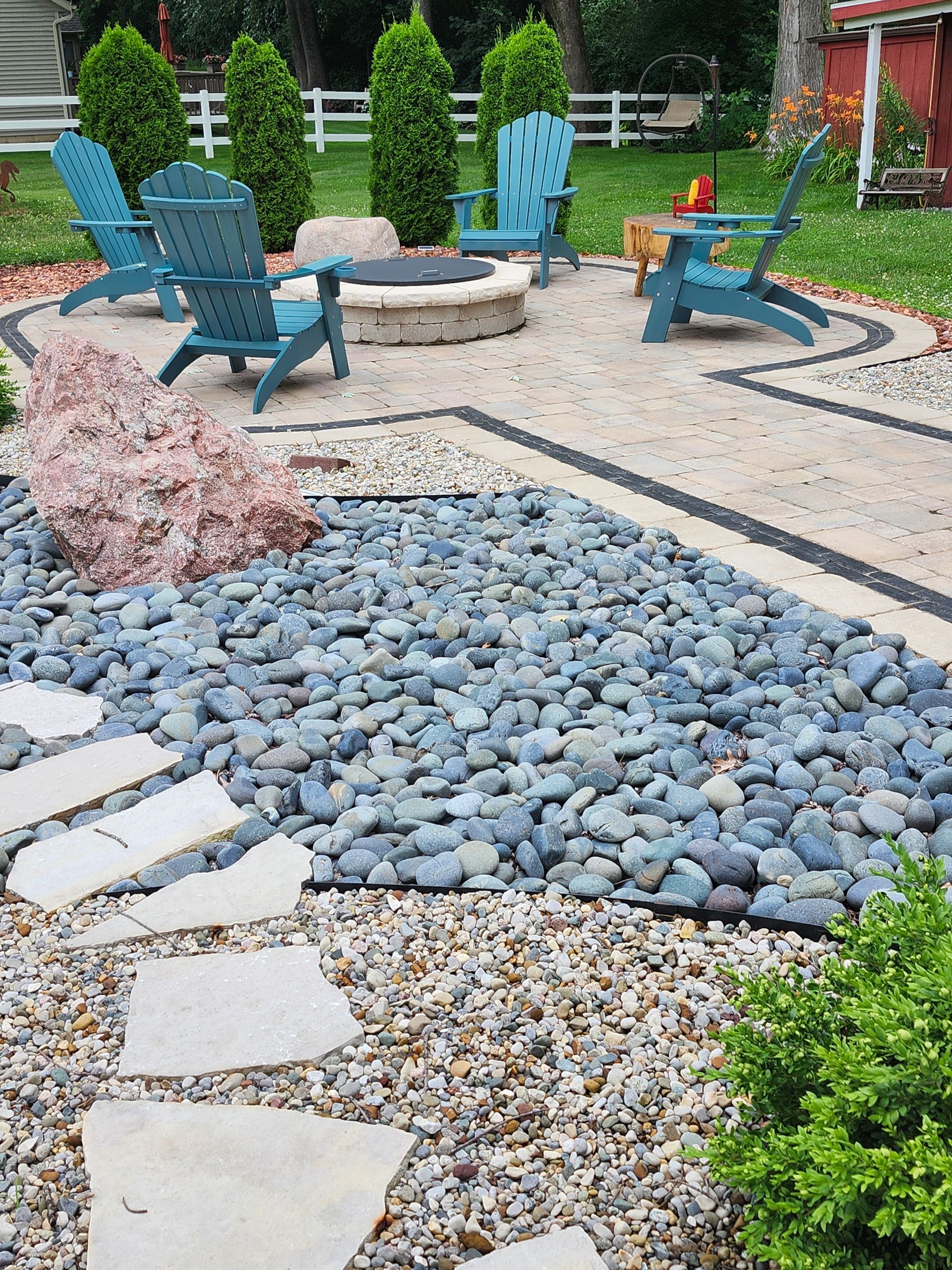 A patio with blue chairs and a fire pit