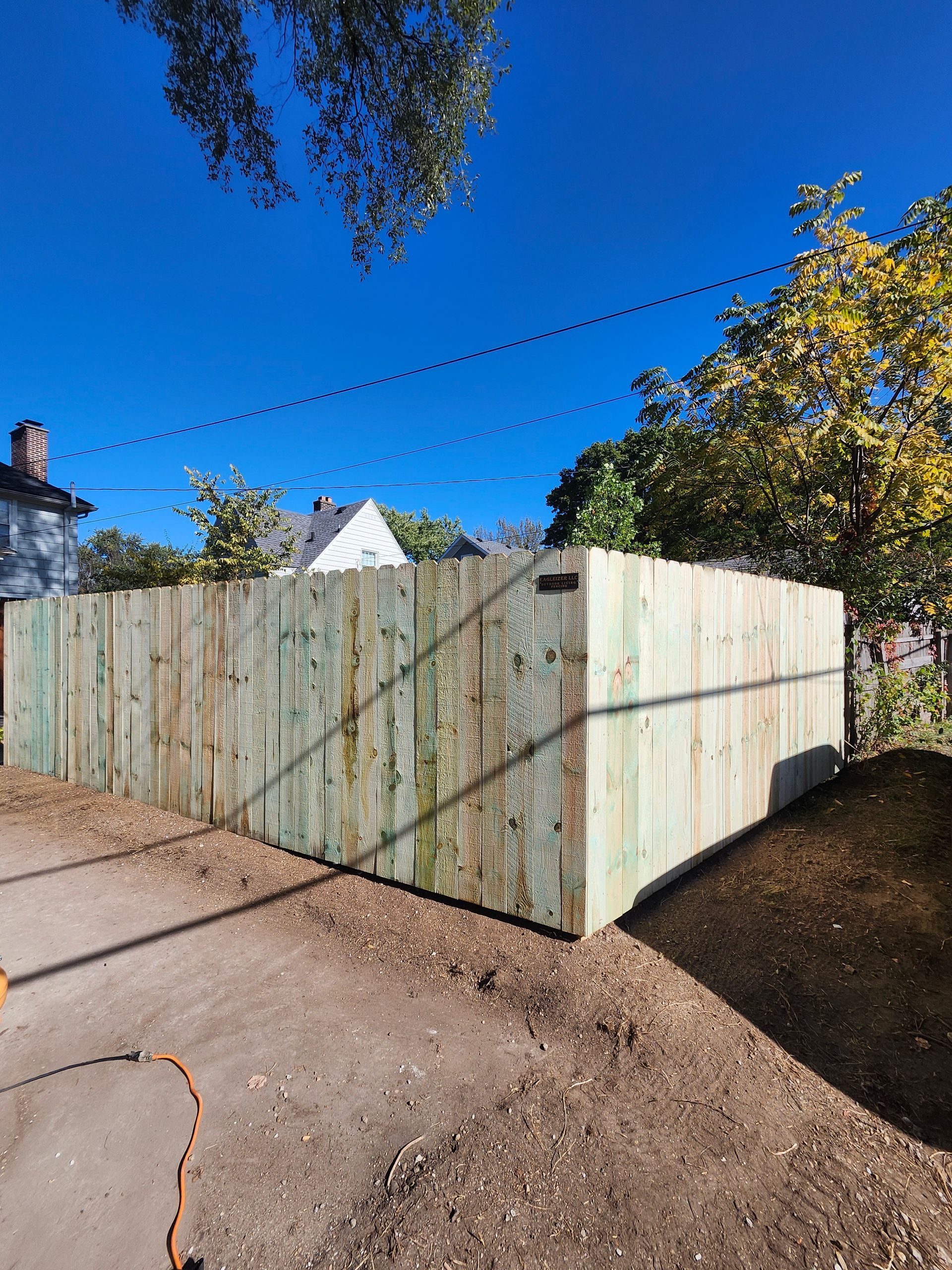 A wooden fence is sitting on top of a dirt hill.