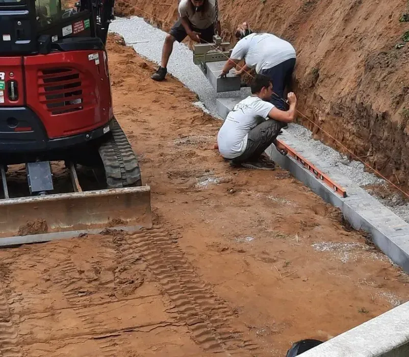 A group of men are working on a construction site next to a yanmar bulldozer.