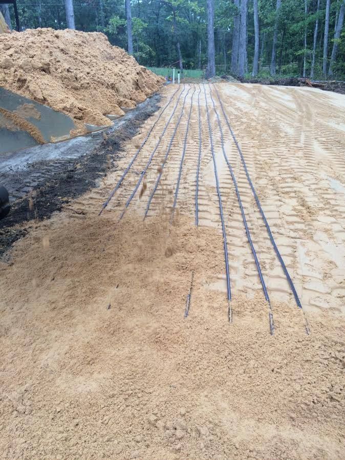 Construction site with graded dirt road and exposed rebar along the center