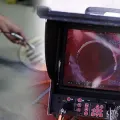 Close-up of a monitor showing an inspection camera view inside a pipe, with control buttons below.