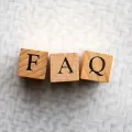 Wooden blocks spelling “FAQ” on a light textured background