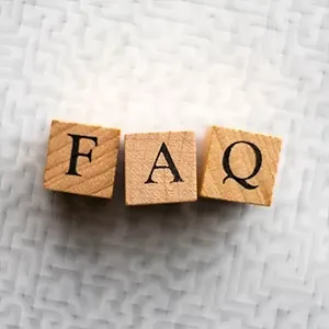 Wooden blocks spelling “FAQ” on a light textured background