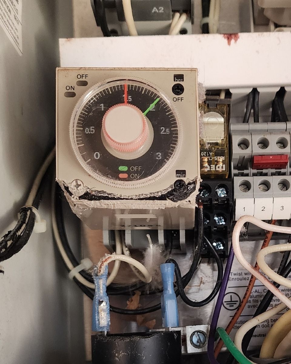 Electrical control panel with a timer relay and wiring inside a cabinet