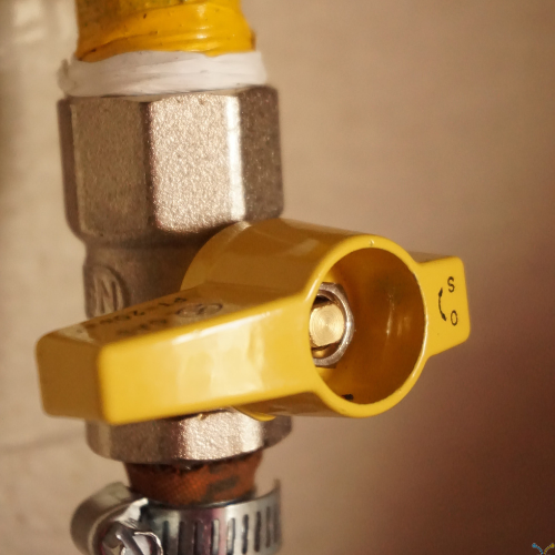 A yellow gas valve with a smiley face on it