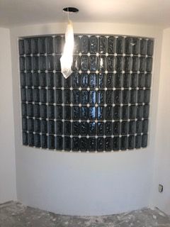 Curved wall with glass blocks, white walls, and a single light fixture.