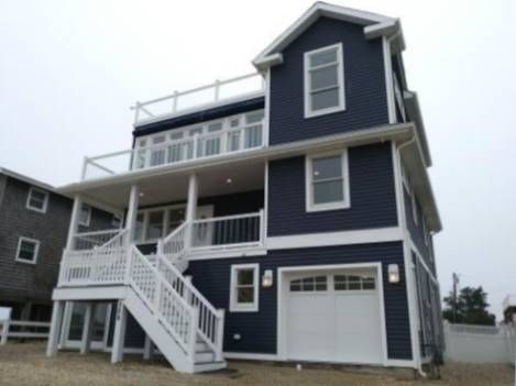 A large blue house with white trim and stairs