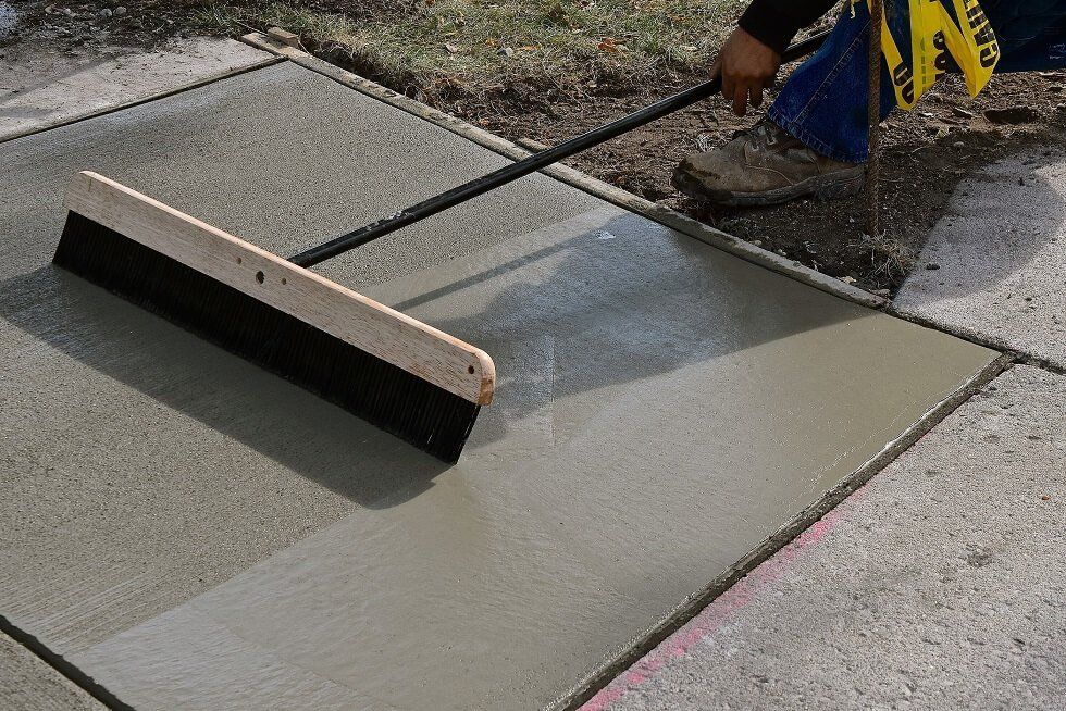 Concreters carrying out broom finishing process for a Bendigo foot path project.
