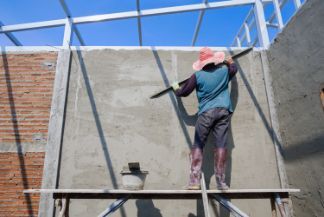 Hardworking concreter working on smoothing and polishing concrete wall in a residential concreting project in Bendigo VIC.