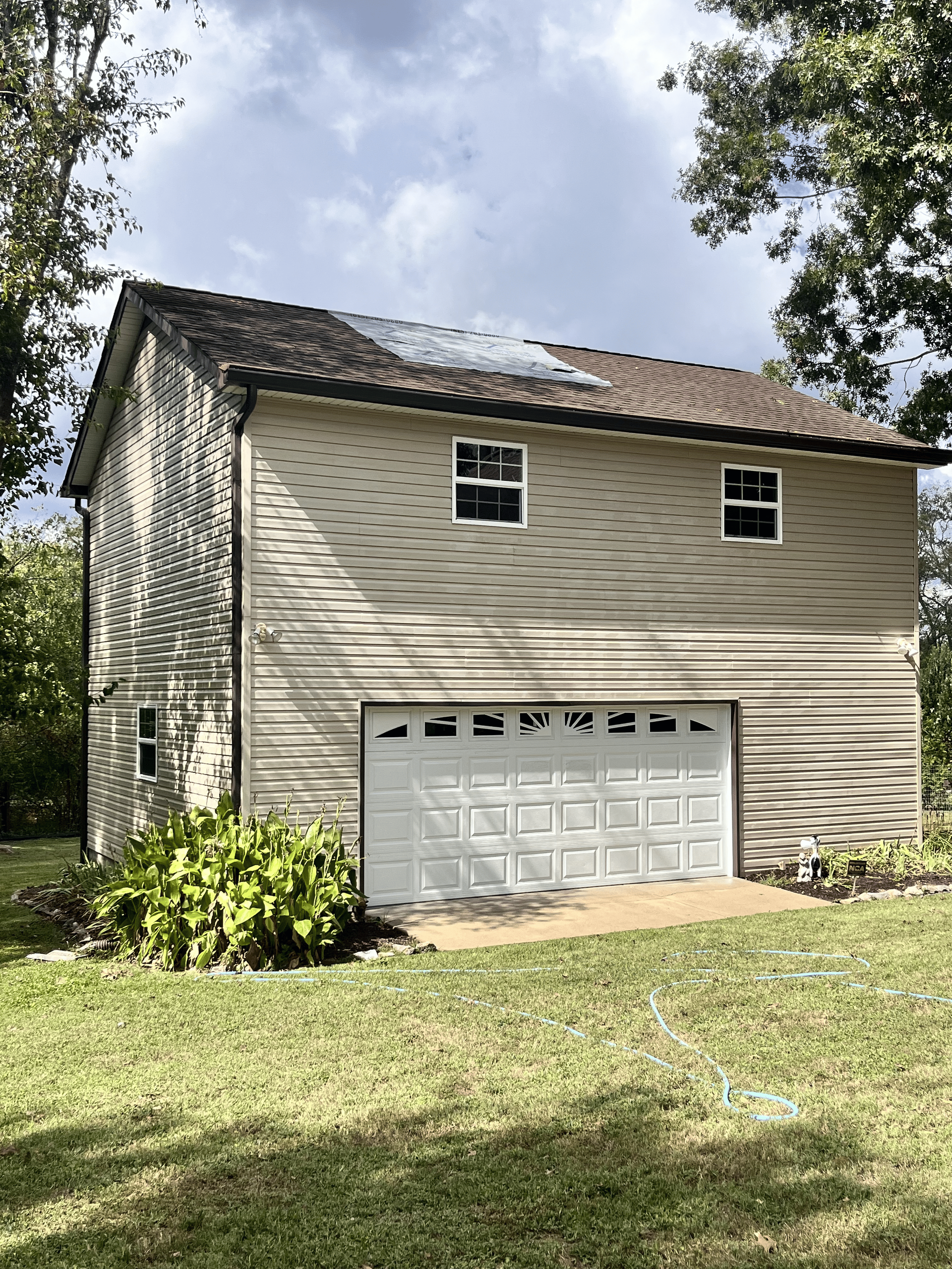 A house with a garage and a roof with solar panels on it.