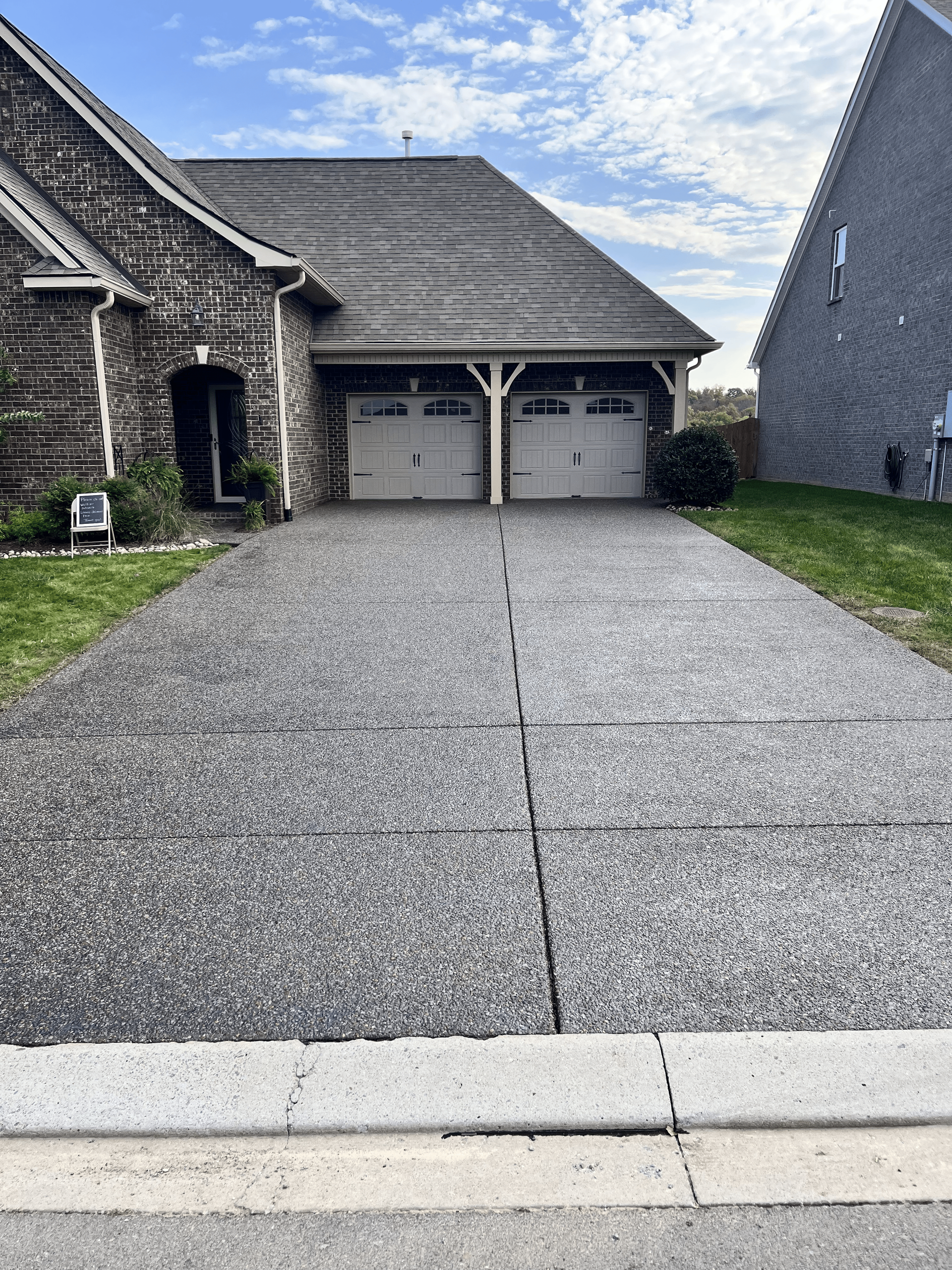 A driveway leading to a house with two garage doors