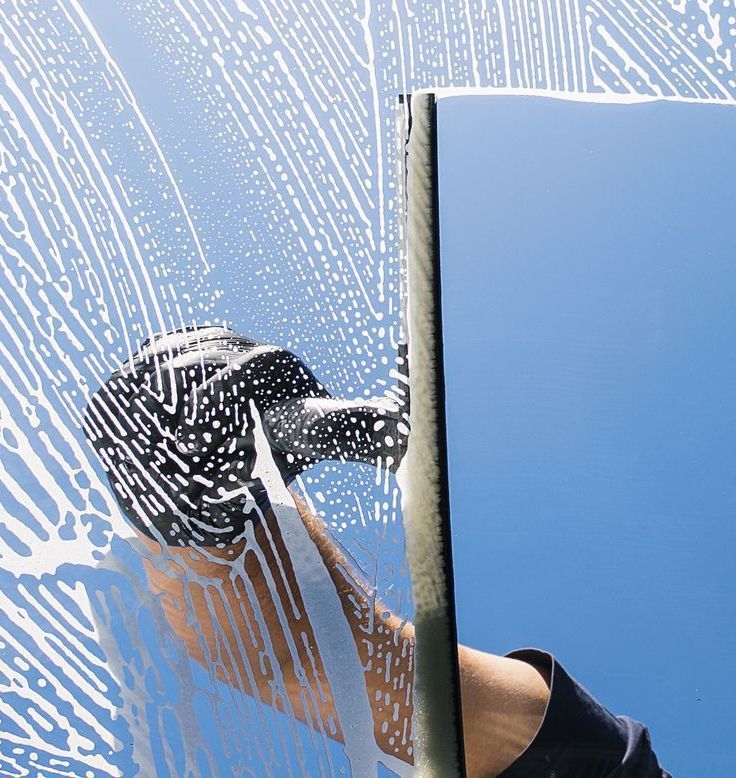 A person is cleaning a window with a sponge