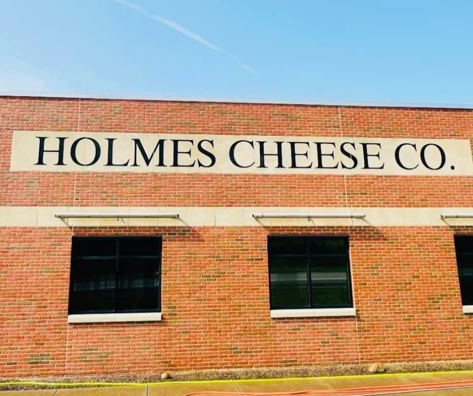 A brick building with a sign on the side that says holmes cheese co.
