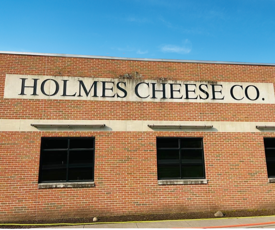 A brick building with a sign that says holmes cheese co.