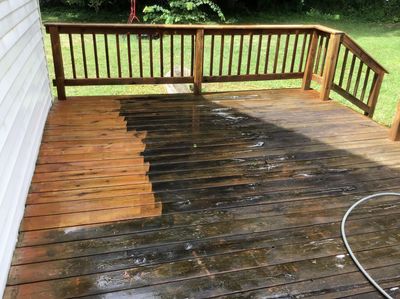 A wooden deck is being cleaned with a pressure washer.