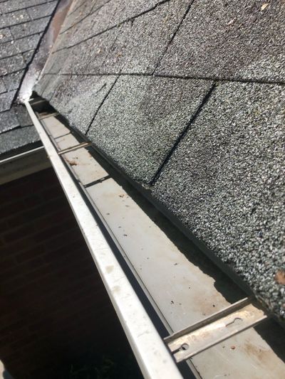 A close up of a gutter on a roof of a house.