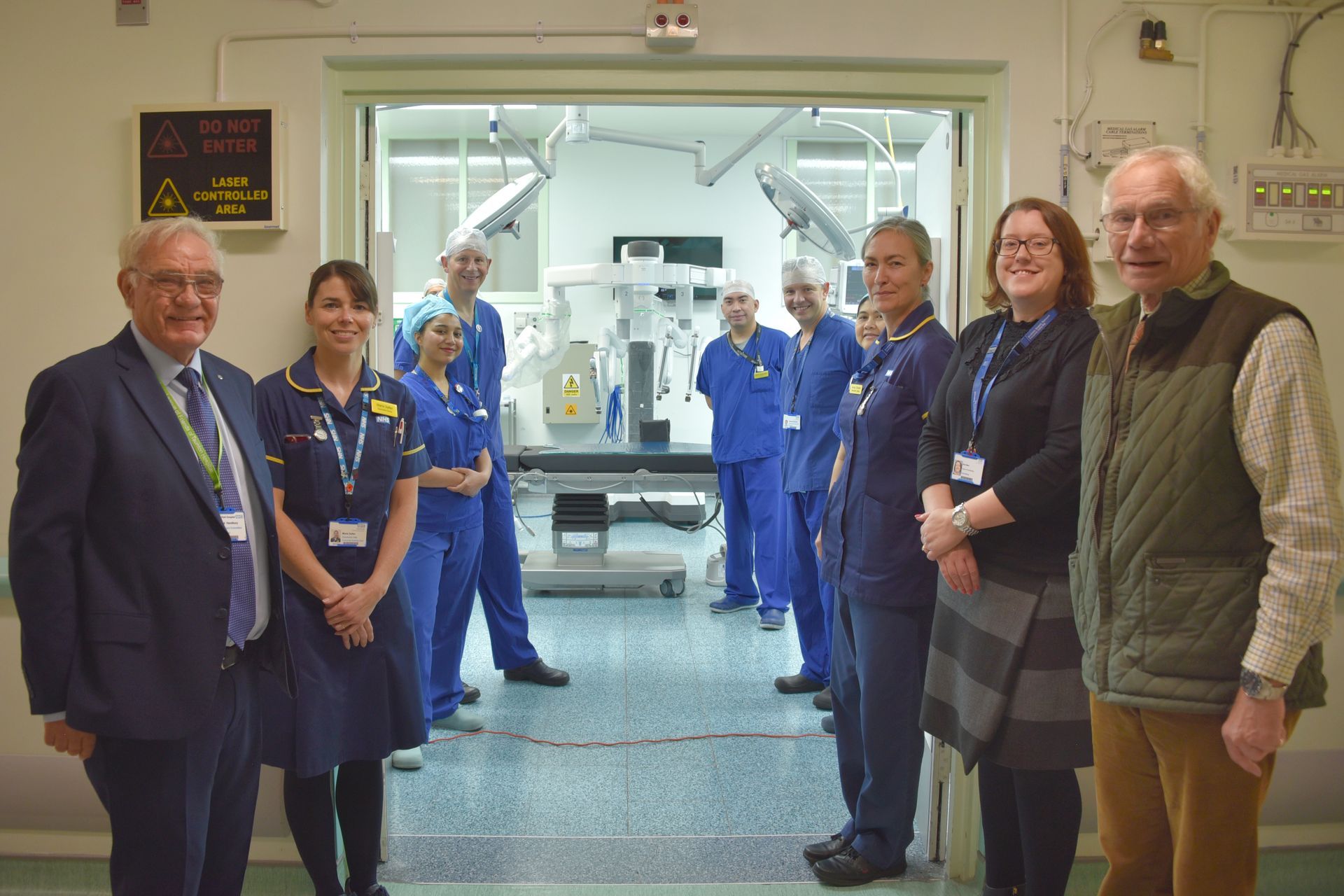 A group of people are standing in front of an operating room.