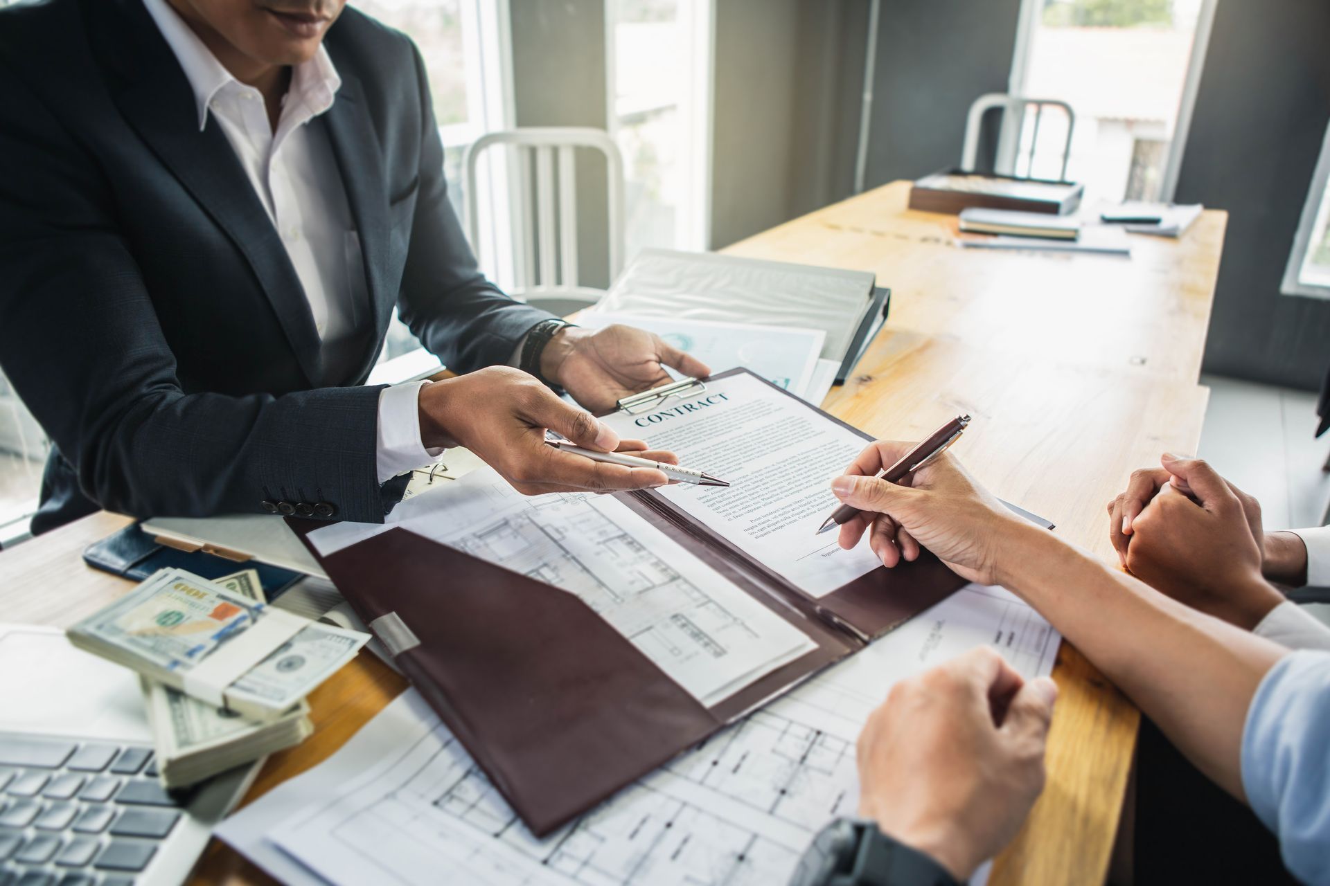 Customer signing contract documents for realty purchase.