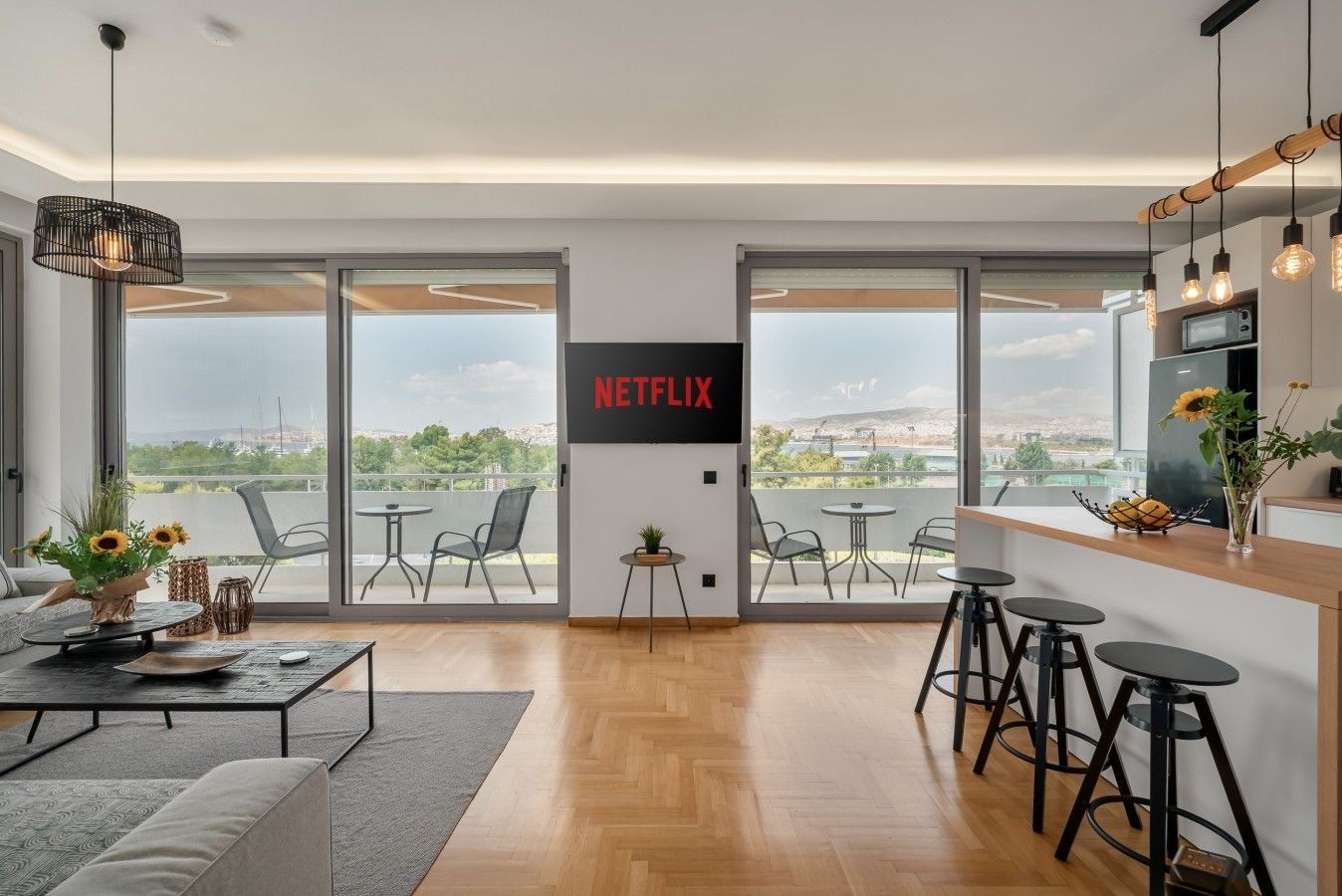 Living room with floor-to-ceiling glass at Faliro Blue, Athens Riviera, set up and operated by Cheez