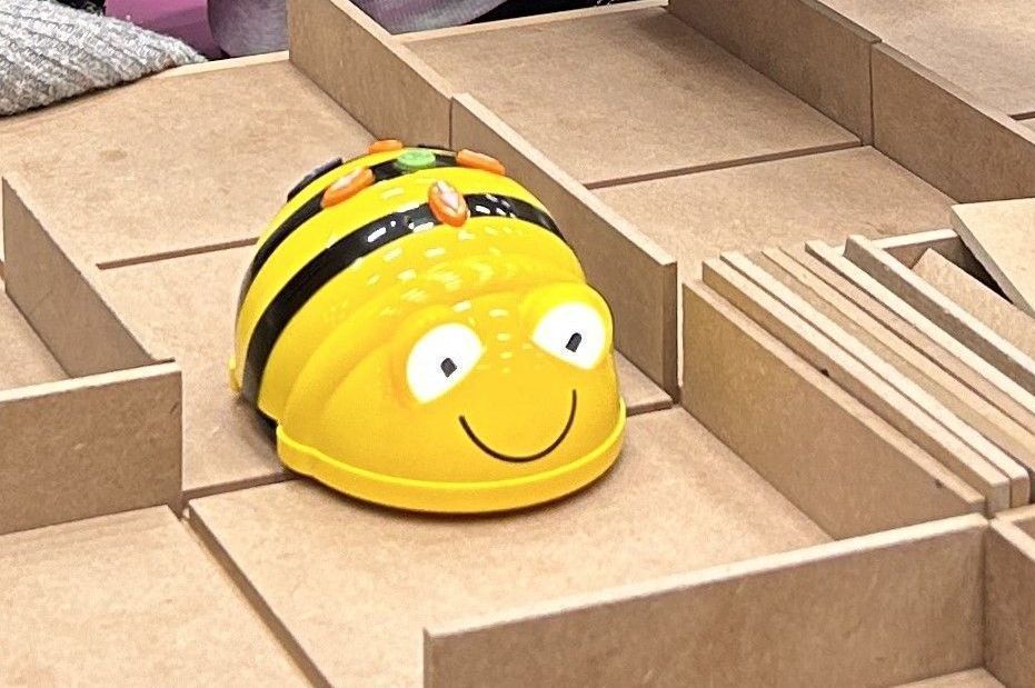 Eine gelbe Roboterbiene kriecht durch ein hölzernes Labyrinth