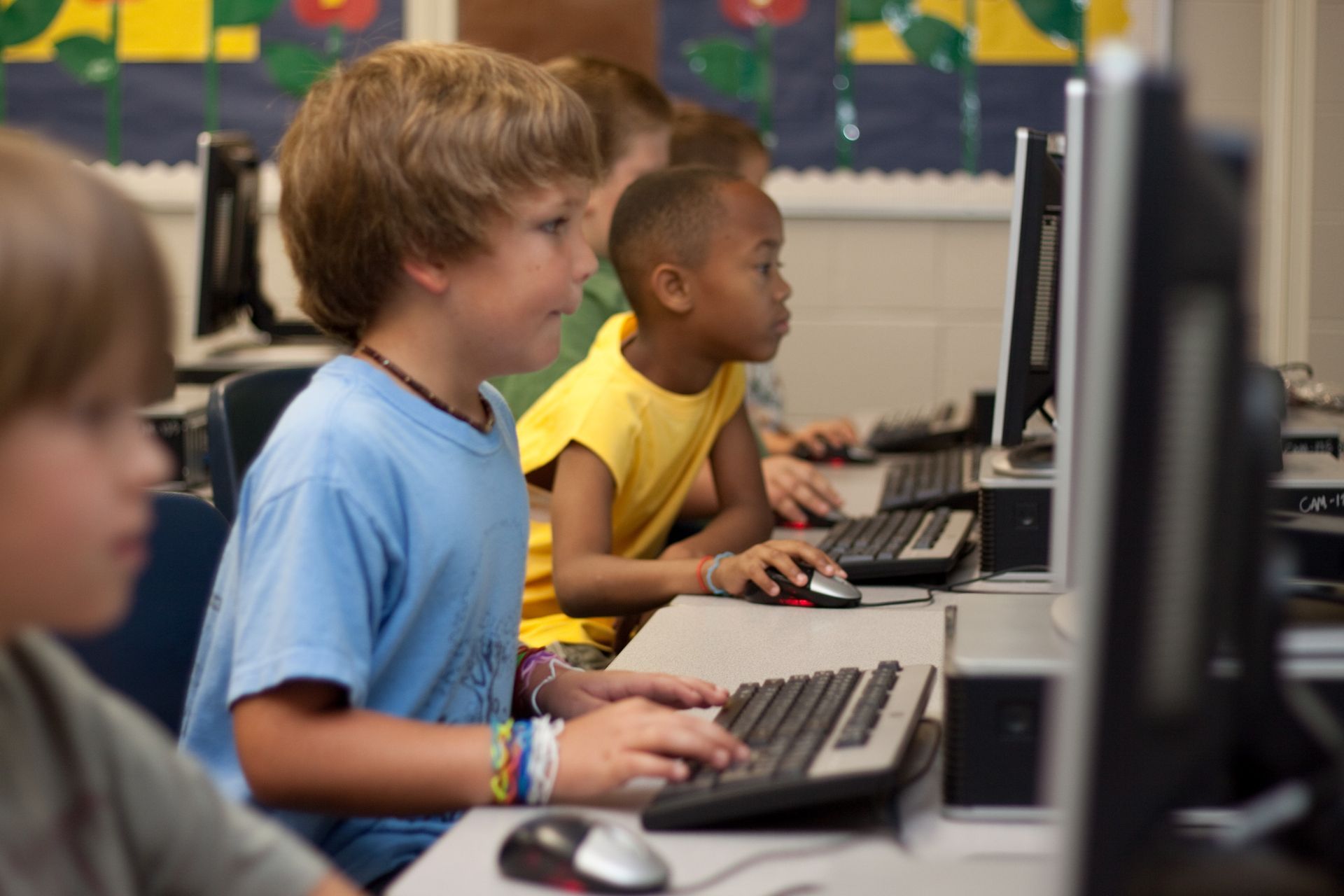 Eine Gruppe von Kindern benutzt in einem Klassenzimmer Computer.