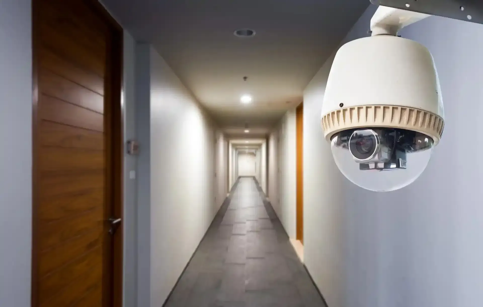Telecamera di sicurezza in un lungo corridoio con porte su un lato.