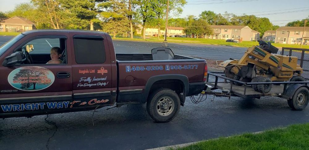 A truck is towing a stump grinder on a trailer.