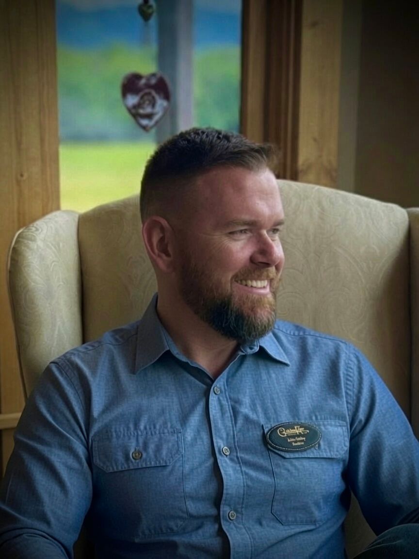 Smiling man in a navy shirt against a blurred indoor background