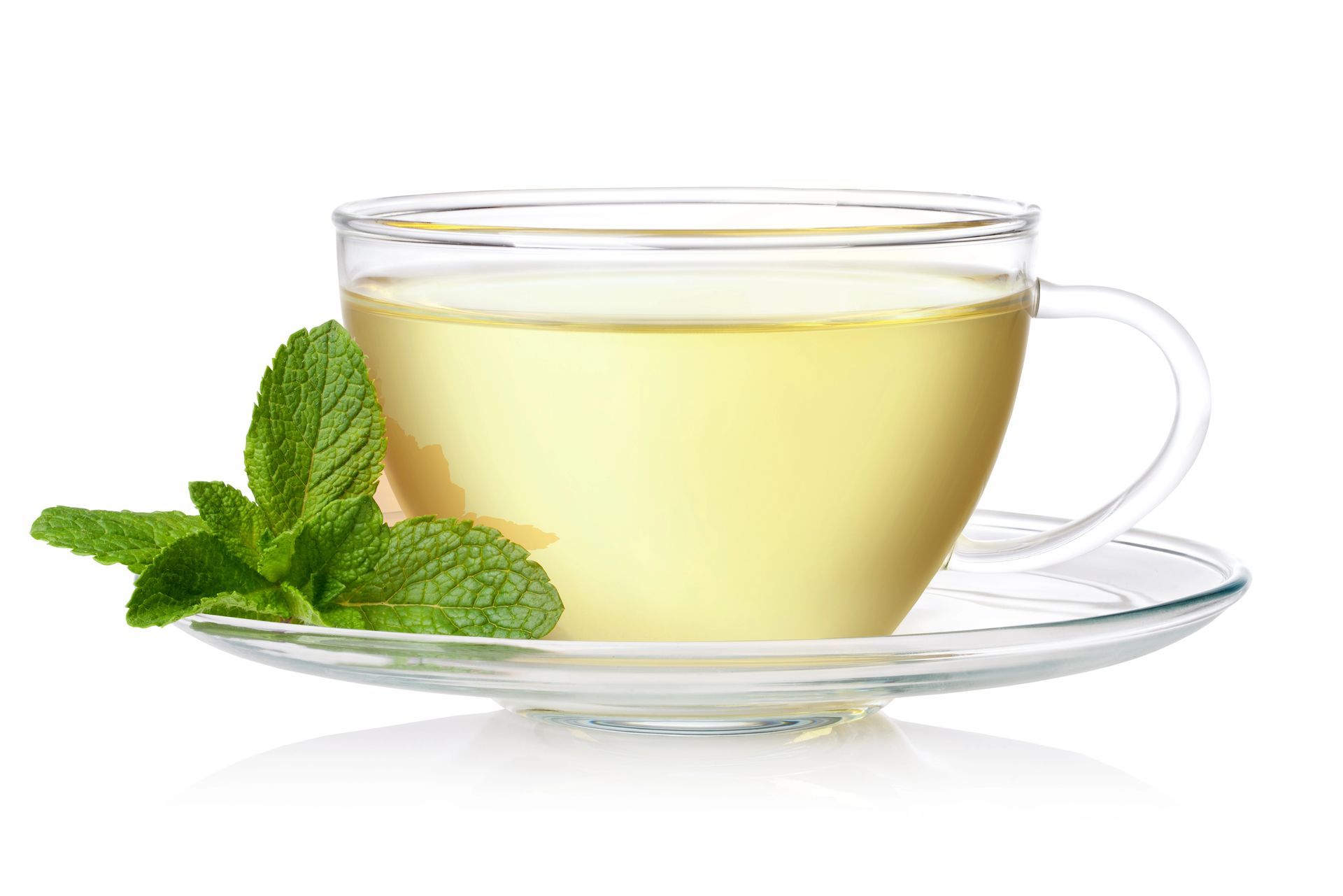 Una tazza da tè in vetro trasparente con un tè leggero su un piattino, con un rametto di menta accanto.