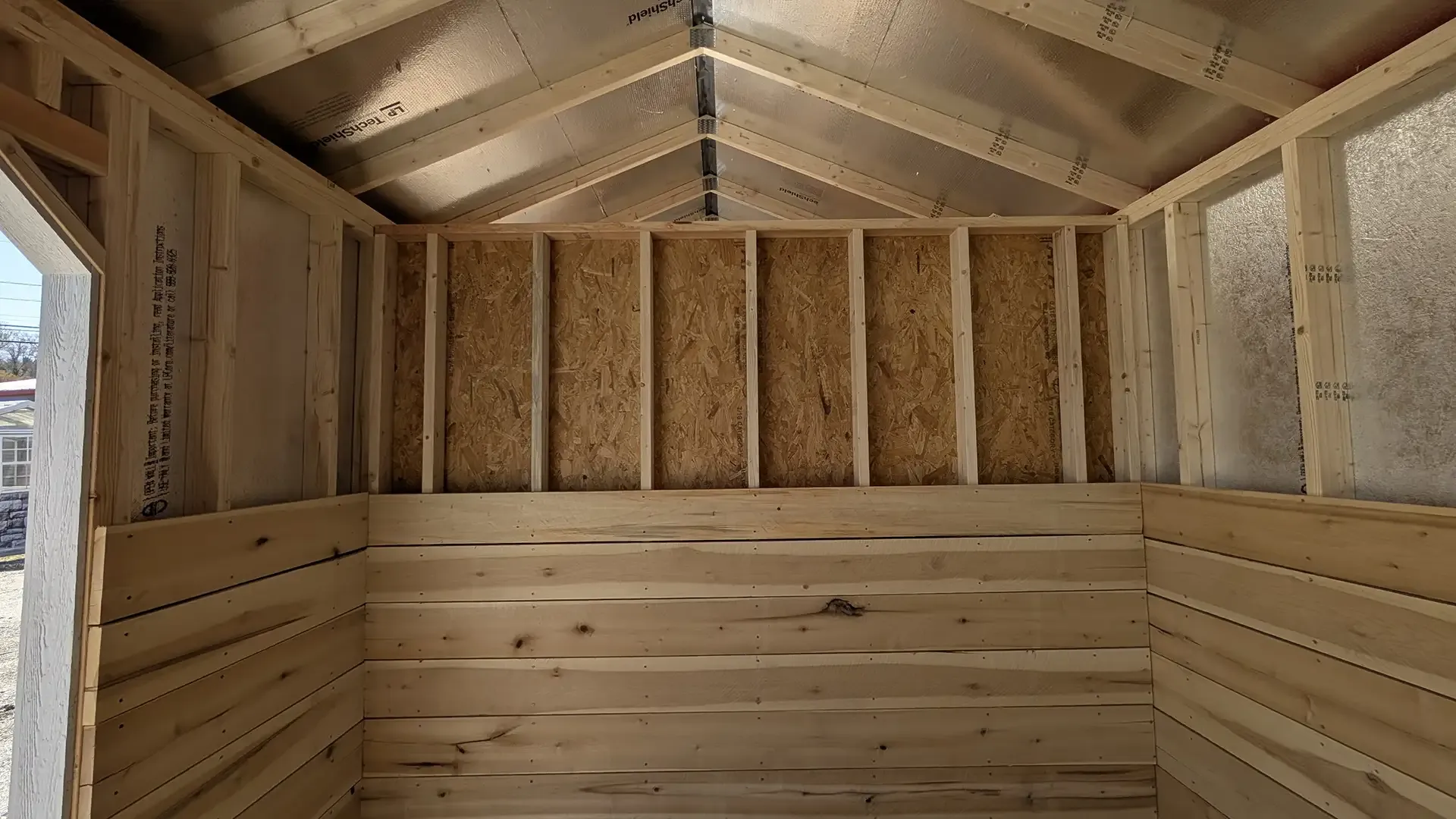 Interior of a wooden structure under construction, showing framing and walls.